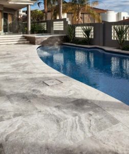 French pattern silver travertine tiles around a pool area.