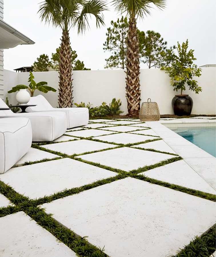 White Limestone pavers laid outside in between grass.